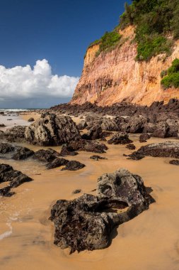 Beautiful view to wild Madeiro beach with rocks and orange sand clipart