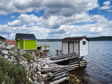 Newfoundland 'da okyanusun kıyısındaki parlak balıkçılık sahnesi binaları.