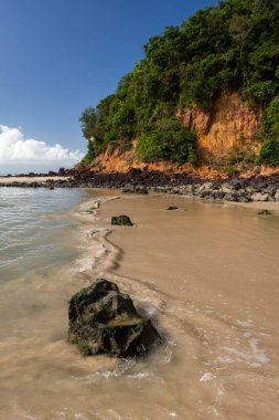 Beautiful view to wild Madeiro beach with orange sandy cliff clipart