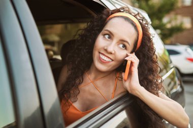 Arabadaki kadın dışarıda telefonla konuşuyor.