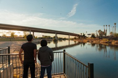 People looking at river at sunset Yuma, AZ clipart