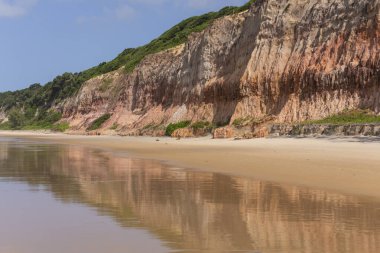 Beautiful view to wild Baa dos Golfinhos beach with orange sand  clipart