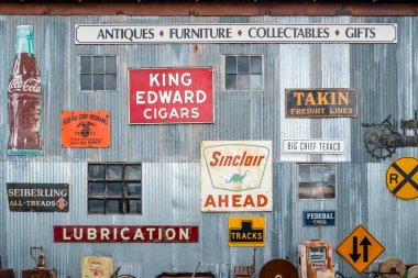 Various metal signs hang on corrugated steel siding clipart