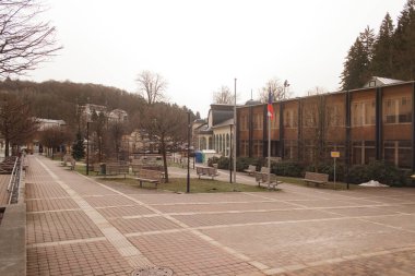 Kışın ıssız bir kasaba meydanında boş banklar.