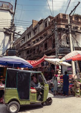 Rawalpindi 'de pazar İslamabad' ı önünde bir motosikletle kapatıyor.