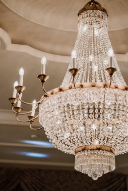 Lüks bir odada ışıldayan zarif kristal avize..