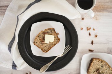 Mutfak masasında taze pişmiş muzlu ekmek ve kahve.