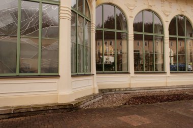 Başka bir binayı yansıtan kemerli pencereli binanın dış yüzeyi