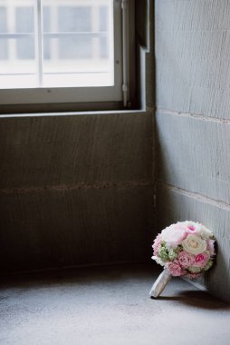 Yumuşak ışıkta bir pencerenin yanında pembe ve beyaz güller buketi