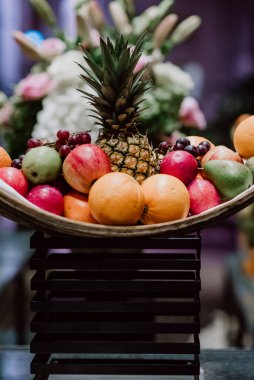 Ananas, elma, portakal ve üzümle canlı meyve düzenlemesi