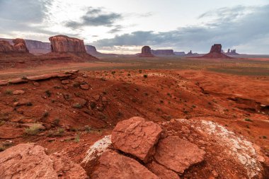 Anıt Vadisi 'nin uçsuz bucaksız çöllerinde kırmızı kayalar ve yüksek popolar hüküm sürüyor.