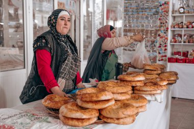 İki kadın markette ekmek satıyor.