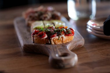 Ahşap masada oturan bir bruschetta tahtası.