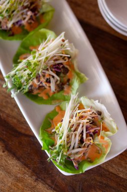 Bir tabak sebze marulu tahta masaya sarılmış.