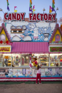 Şeker fabrikasından elma şekeri alan küçük bir çocuk.