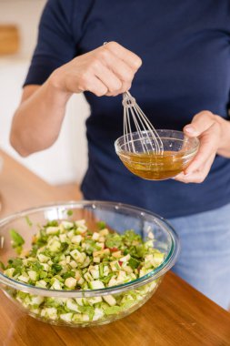 Meyve salatasının üzerinde sirke tutan kadın.