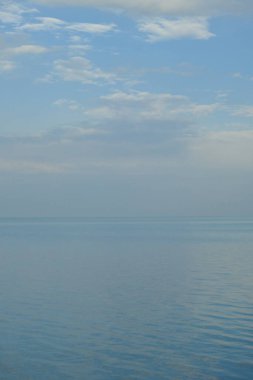 Suyun gökyüzüyle buluştuğu ve ufkun harmanlandığı sakin bir sahne.