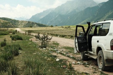 Exploring the mountains of kyrgyzstan in a large all-terrain vehicle clipart