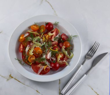 Fresh salad of  cherry tomatoes and citrus fruits in a white  plate clipart