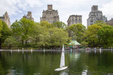 Model boat sailing in pond in Central Park NYC clipart