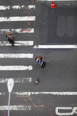 Passers-by cross street from above looking down clipart