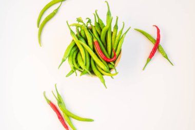 Beyaz arka planda bir kase taze yeşil ve kırmızı biber.