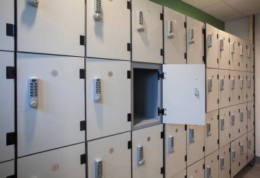 A wall of white lockers with keypads clipart