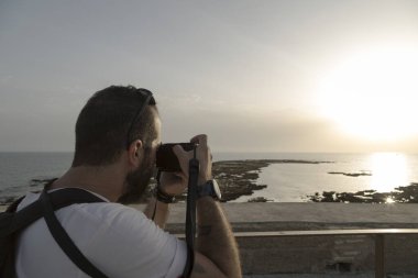 Bir adamın rahatlatıcı görüntüsü Deniz kenarında bir gün batımı