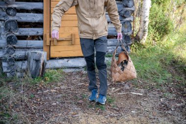 Man with firewood in basket clipart