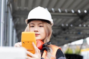 Dışarıda çalışan kasklı genç bir mühendis.