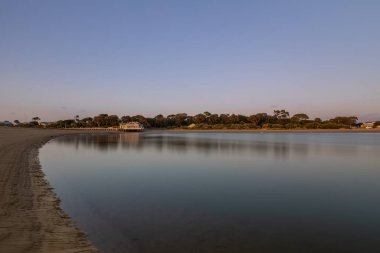 Barwon Heads Nehri 'nde güneşin doğuşunu yansıtan durgun su