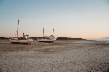 Slettestrand sahilinde balıkçı tekneleri, Danimarka, gün batımında deniz kenarında.