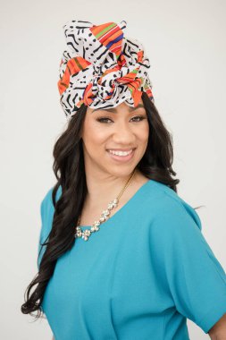 Woman smiling wearing a headwrap with her blue outfit clipart