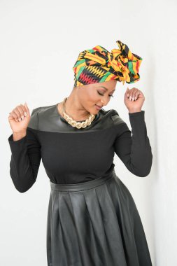 Nijeryalı kadın başörtüsü takıp dans ediyor.