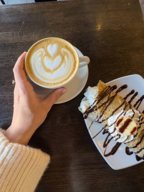 Sıcak bir kafede krep tatlısı ile latte