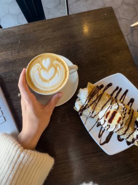 Sıcak bir kafede krep tatlısı ile latte