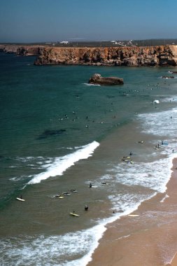 Praia do Tonel in Sagres, Algarve, Portekiz 'deki dalgalarda sörfçüler