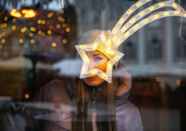 Woman smiling through illuminated star decoration clipart