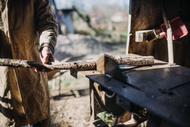 Testereyle dalları kesen bir adamın yakın çekimi..