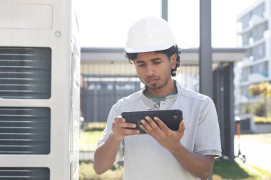 young technician with tablet controlling outside clipart