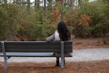 Woman enjoying a Fall walk in the forest clipart