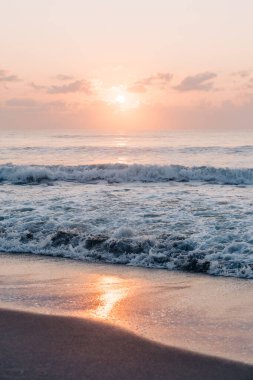 Sıcak gün doğumu plajda yansıyor yumuşak dalgalar ve yumuşak köpüklerle