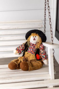 Scarecrow on a White Porch Swing clipart