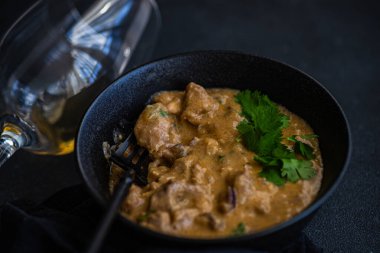 Biftek stroganof tabağı kasede servis ediliyor.