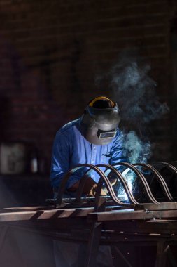 Welder building an iron gate in Alamos, Sonora, Mexico clipart