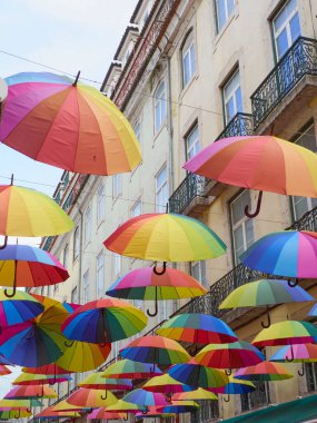 Bir caddeyi süsleyen çok renkli şemsiyeler