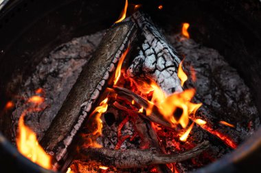 Ateş ve külleri sonbaharda dışarıdaki bir ateş çukuruna yakın çekim.