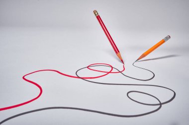 Kırmızı ve siyah kalemler girdap çiziyor.