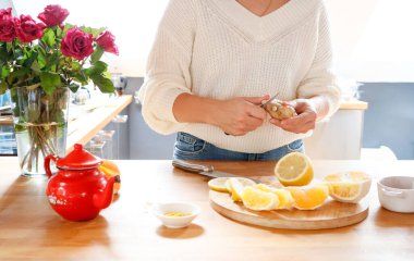 Kadın limon, zerdeçal, zencefil ve portakallı vitamin çayı hazırlıyor.