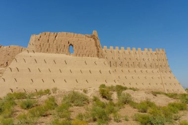 Küçük pencereli, büyük, çökmüş bir duvar.